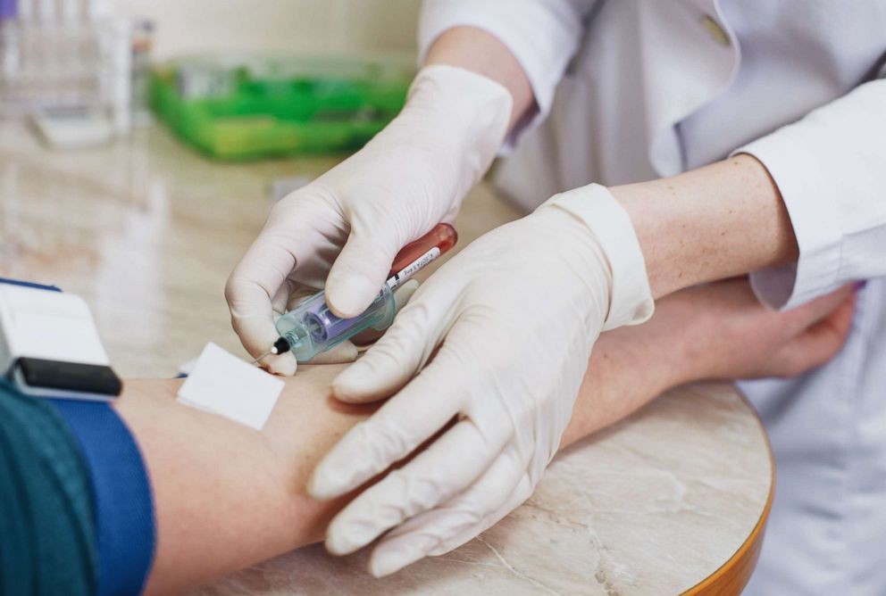 Nhân viên y tế lấy máu xét nghiệm đường huyết lúc đói